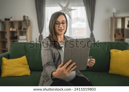 Pregnant woman doing online shopping hold credit card sit at home