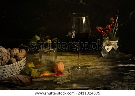 still life: glass of wine, painted picture, cookies, vases, leaves