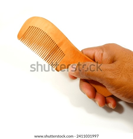 a wooden comb holding hand on white background close-up view single object, hand holding comb isolated on white, eco friendly no wastage product showing concept Royalty-Free Stock Photo #2411031997