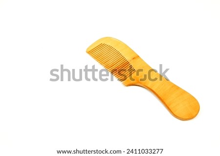 a wooden comb isolated on white background close-up view single object, eco friendly no wastage product concept copy space  Royalty-Free Stock Photo #2411033277