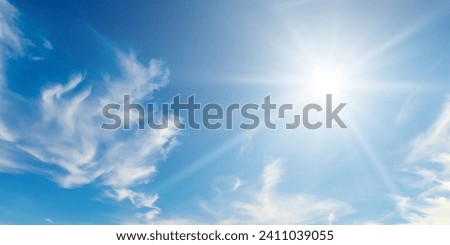 Cumulus clouds and bright sun in the blue sky. Wide photo.