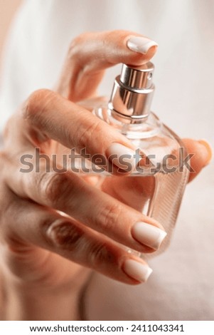 Woman holding glass parfume bottle atomizer fragrance aroma Royalty-Free Stock Photo #2411043341