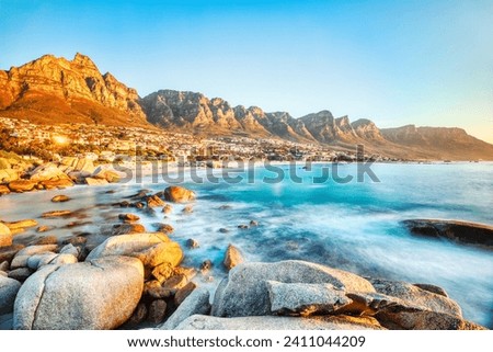Cape Town Sunset over Camps Bay Beach with Table Mountain and Twelve Apostles in the Background, South Africa  Royalty-Free Stock Photo #2411044209