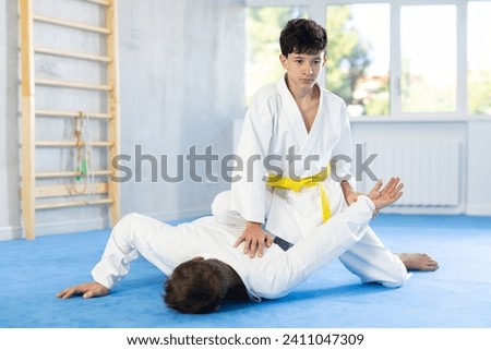Adult man and teenage boy judokas practicing judo fighting in studio