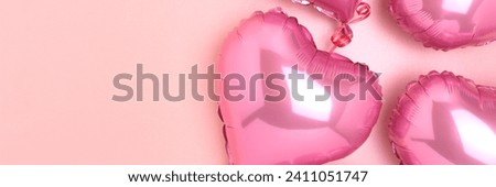 Banner with pink foil balloons in a heart shape. Monochrome festive concept on a glittering background.