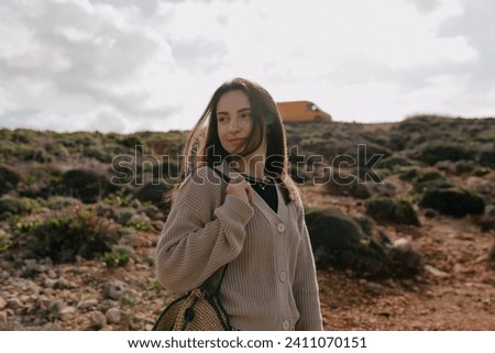 Beautiful caucasian woman traveling with backpack in mountains. Brown hair female wears beige sweater spend time outdoor. Concept weekend, lifestyle. Royalty-Free Stock Photo #2411070151