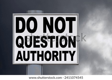 Close-up on a white billboard against a threatening sky with the message "Do not questioned authority" written in the middle.