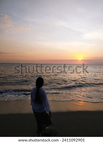 A girls who see the sunset at beach in Indonesia