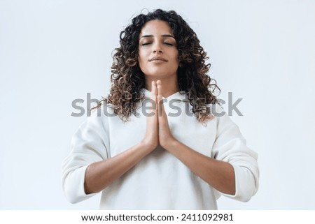 Shot of zen peaceful woman dressed in a white tracksuit doing yoga poses in the studio