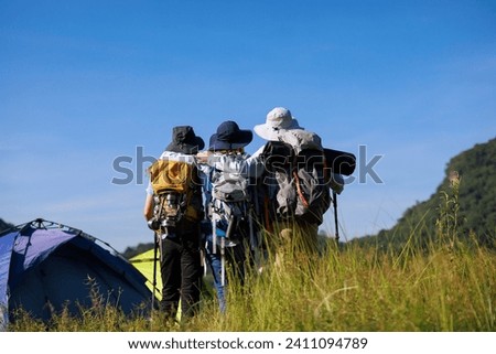 back view family trekking on the hill and blue sky background, backpacker and camping concept,