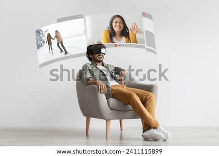 Future of communication. Young arabic man indulges in VR-enhanced video conversations from home, talking with his loving wife via digital screen Royalty-Free Stock Photo #2411115899
