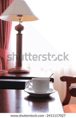 a cup o f coffee at classic style work and living room with classic style chairs, tables and curtains