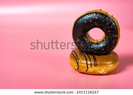 Fresh donuts on a pink background. Royalty-Free Stock Photo #2411118267