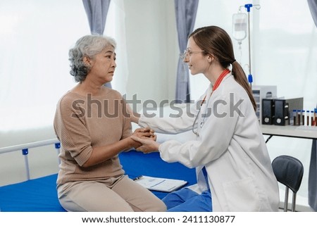 A female doctor talks to an elderly female patient while looking at her test results. A patient is consulting a female doctor about treatment and health advice.