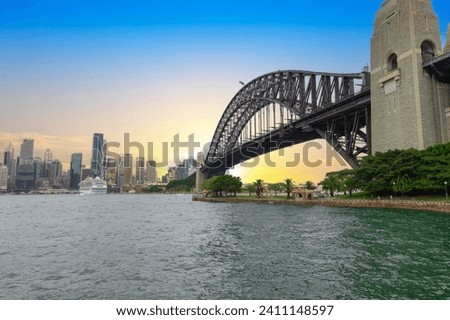 Sydney Harbour viewed from North Sydney with Sydney City Skyline and CBD high-rise, circular quay and Harbour Bridge. Cruise Liner Ship docked on wharf colourful skies NSW Australia Royalty-Free Stock Photo #2411148597
