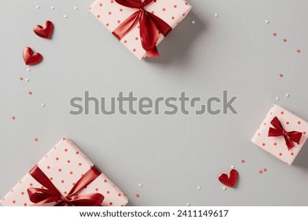 Valentines Day background with gift boxes and hearts candy on grey table. Top view. Flat lay.