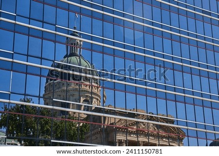 Modern Meets Historic: Reflection of Ornate Courthouse in Glass Skyscraper