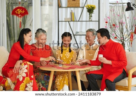 Big Vietnamese family gathered together to write calligraphy couplets for Tet celebration Royalty-Free Stock Photo #2411183879