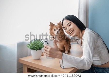 Portrait of asian young woman with computer stay home sit on table selfie with her dog desk with lovely dog. Happy moment of pure love. Asia girl playing with little dog. Love together family.