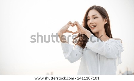 Portrait of young beautiful asian woman hands gesture in heart shape on city sky roof top. Smile face asian lady girl wear casual cloth. Japanese girl lifestyle, lovely woman valentines’ day concept  Royalty-Free Stock Photo #2411187101