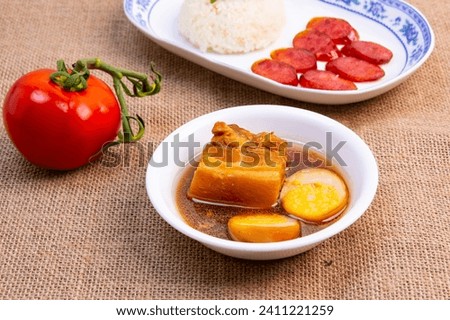 Vietnamese braised pork with eggs is a popular dish in Vietnamese cuisine. It is made by braising pork belly with fish sauce, sugar, garlic, and chili peppers. Royalty-Free Stock Photo #2411221259