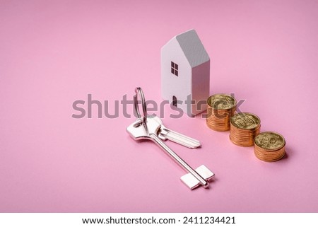 A small wooden house and keys as an idea for investing in your own home and achieving the goal of buying real estate. Background for your idea