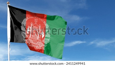 Afghanistan flag on cloudy sky. flying in the sky Royalty-Free Stock Photo #2411249941