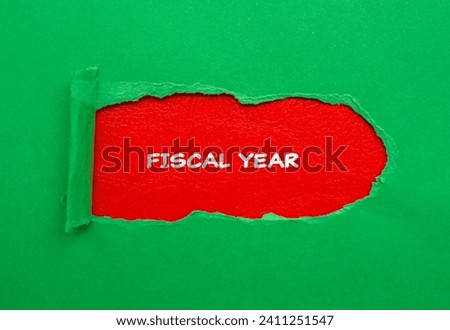 Fiscal year lettering on ripped green paper with red background. Conceptual business photo. Top view, copy space for text.