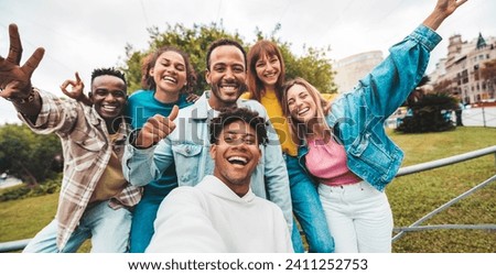 Multiracial friends taking selfie with smart mobile phone outside - Happy young people smiling at camera on city street - Youth community concept with guys and girls hanging out on summer day 