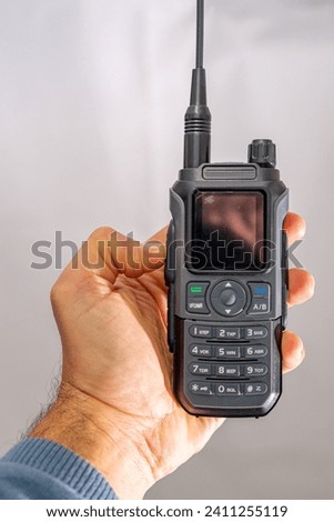 amateur radio walkie talkie portable triband held in the hand of a white man Royalty-Free Stock Photo #2411255119