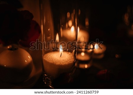 Burning candles for surprise marriage proposal. Luxury candlelight date in restaurant. Romantic dinner setup at night. Table set for couple, Valentine's Day evening. Decoration candle. Details closeup