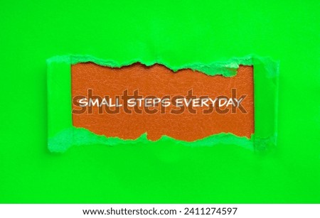 Small steps everyday lettering on ripped green paper with brown background. Conceptual photo. Top view, copy space for text.