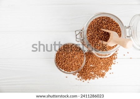 Raw buckwheat in a bowl on a textured wooden background. Wheat grains, porridge, cereals, raw buckwheat in a plate. Healthy food. Porridge. Diet. Organic cerea. Space for text.Copy space.