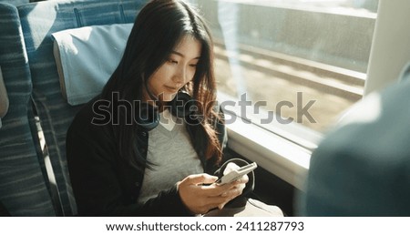 Japan woman, travel and train on smartphone, social media and public transportation on metro bullet. Person, cellphone and online on fast vehicle for weekend trip and commute in tokyo for adventure Royalty-Free Stock Photo #2411287793