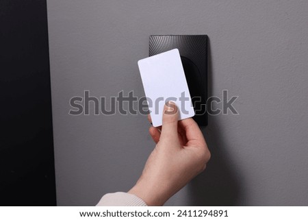 Woman opening magnetic door lock with key card, closeup. Home security Royalty-Free Stock Photo #2411294891