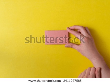 person's hand holding a pink card