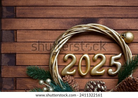 Happy New Year golden numbers 2025 on cozy festive brown wooden background with sequins, snow, lights of garlands. Greetings, postcard. Calendar, cover
