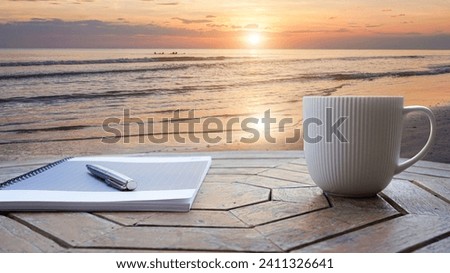 Notebooks, pens, coffee cups on a rooftop by the sea. cup of coffee on the nature background.                               