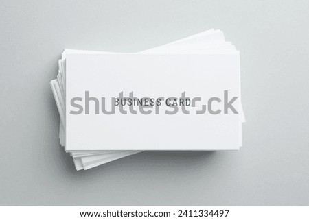 Stack of business cards on light grey background, top view