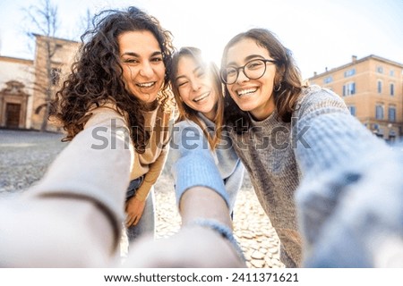 Three young women taking selfie pic with cellphone outside - Happy girls smiling at camera together 
