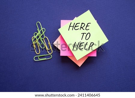 Here to help symbol. Yellow steaky note with paper clips with words Here to help. Beautiful deep blue background. Business and Here to help concept. Copy space.