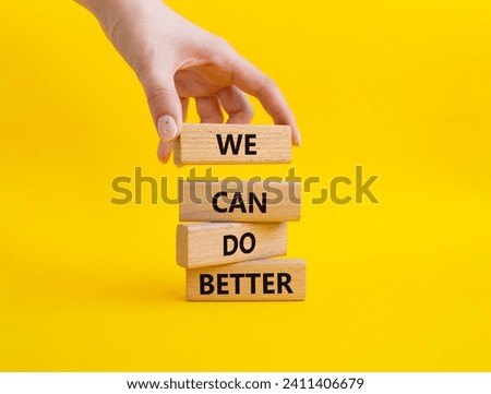 We Can Do Better symbol. Concept words We Can Do Better on wooden blocks. Beautiful yellow background. Businessman hand. Business and We Can Do Better concept. Copy space. Royalty-Free Stock Photo #2411406679