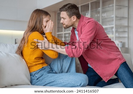 Man tyrant husband beating crying wife during scandal misunderstanding at home. Stressed mad abuser mocks the victim. Domestic physical emotional violence, toxic relationship, marital discord concept. Royalty-Free Stock Photo #2411416507