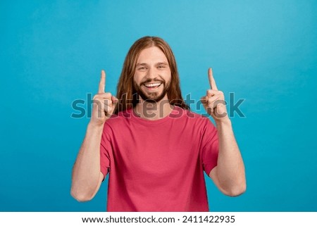 Photo of cheerful nice person toothy smile indicate fingers up empty space isolated on blue color background