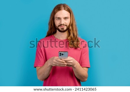 Portrait of attractive guy hold apple iphone gadget empty space ad isolated on blue color background