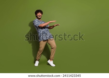 Full body photo of crazy hispanic guy wearing trendy apparel doing dynamic moves catch rhythm dancing isolated on khaki color background