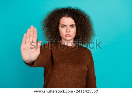 Photo of young upset lady wearing brown pullover makes negative symbol asking stop agism problem isolated on aquamarine color background