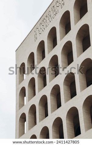 The Palazzo della Civilta Italiana, also known as the Colosseo Quadrato. Translation: "A nation of poets, of artists, of heroes, of saints, of thinkers, of scientists, of navigators, of migrators"