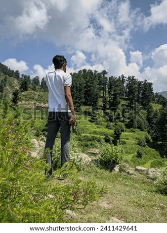 a guy standing at beautiful view from the top of the mountain.