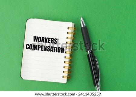 pen and notebook with the words workers' compensation Royalty-Free Stock Photo #2411435259